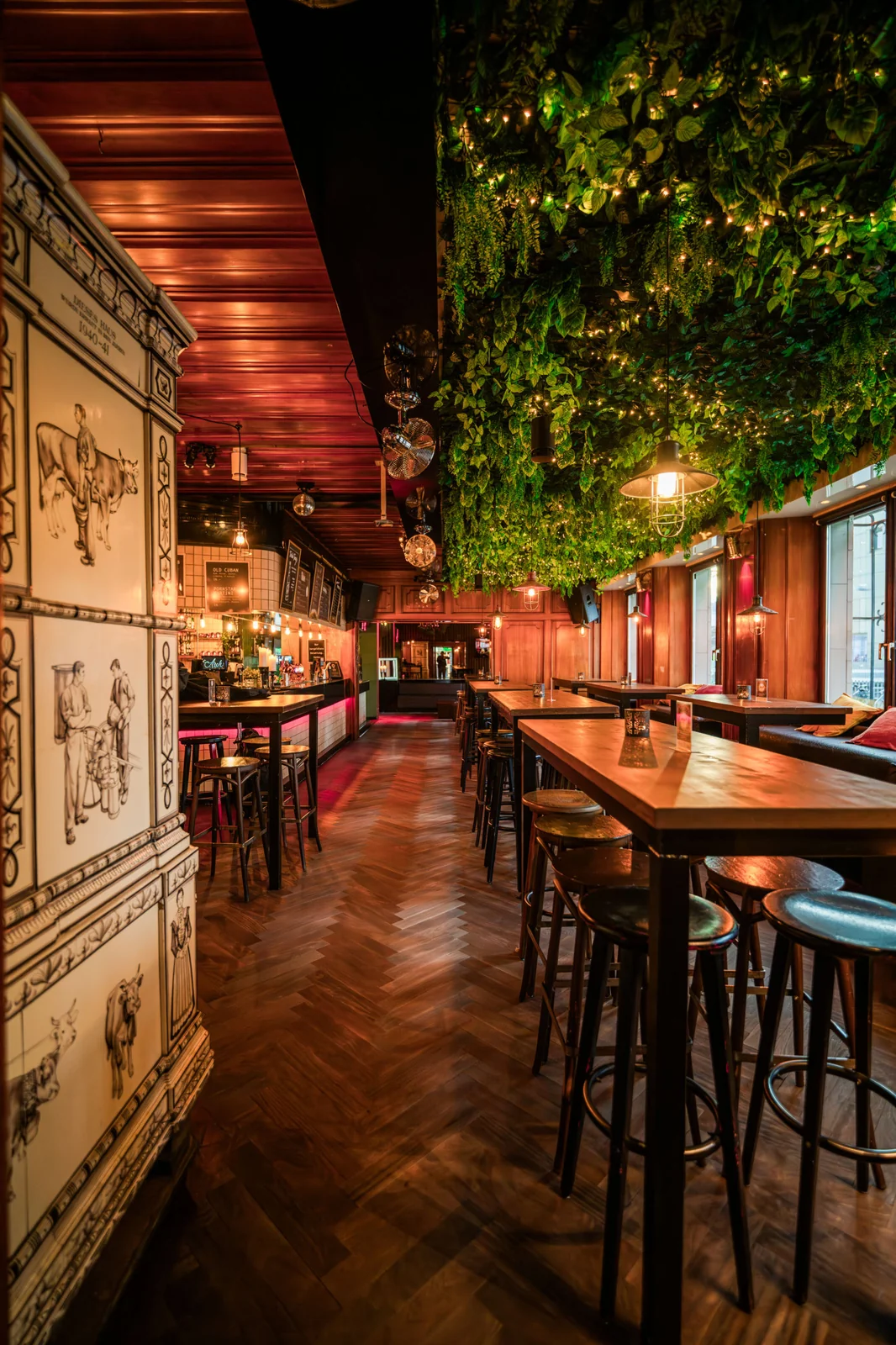 Holztische und grüne Pflanzen unter der Holzdecke der Arch-Bar
